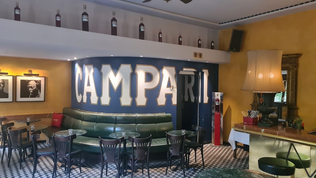 Les grandes lettres Campari au-dessus des banquettes vertes du Campari Bar