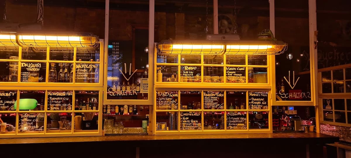 Die beleuchtete Rückbar des Irrsinn mit Flaschen und handgeschriebenen Tafeln