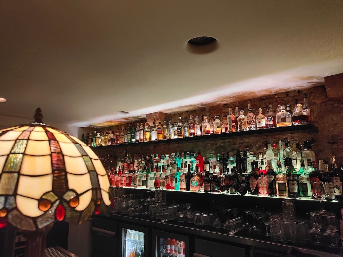 Die Rückbar des Pot Still mit Hunderten Flaschen und einer Tiffany-Lampe