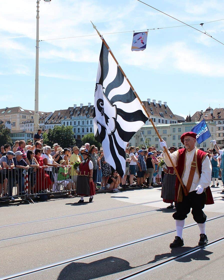 Die Parade des Basel Tattoo in der Basler Innenstadt, Dudelsackspieler in Kilts und Trommler marschieren zwischen Zuschauern am Strassenrand