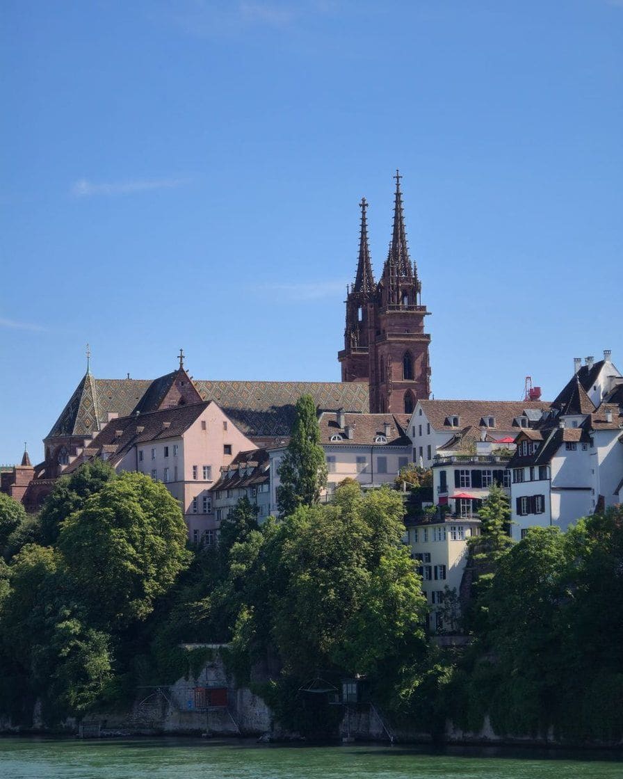 Die Doppeltürme des Basler Münsters aus rotem Sandstein mit dem bunt glasierten Ziegeldach, vom Münsterplatz aus gesehen