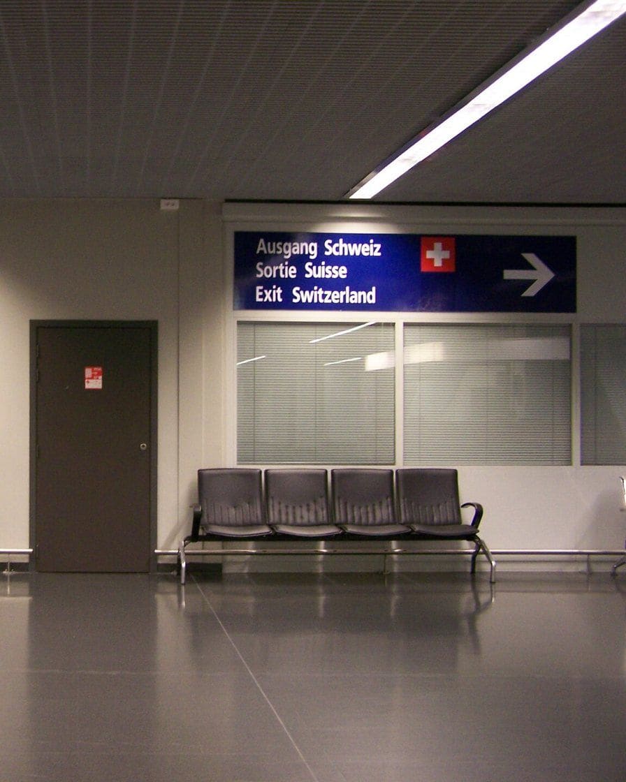 Wegweiser im EuroAirport: links der Ausgang Frankreich und Deutschland, rechts der Ausgang Schweiz