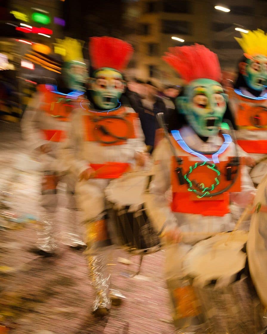 Der Cortège der Basler Fasnacht auf dem Marktplatz vor dem roten Rathaus, kostümierte Pfeifer mit grossen Larven und Zuschauer am Strassenrand