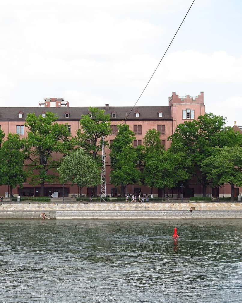 Das Kasernenareal in Kleinbasel vom Rhein aus, das lange Kasernengebäude hinter den Bäumen der Uferpromenade