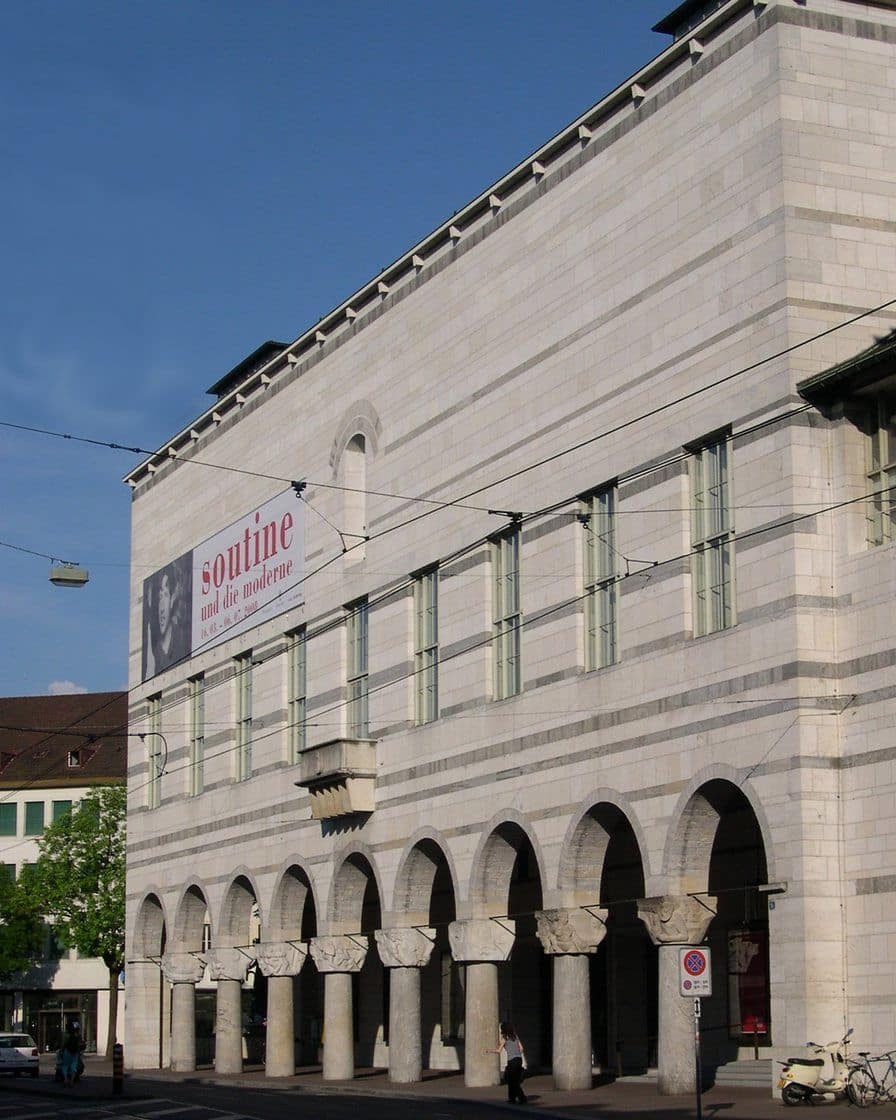 Die Fassade des Hauptbaus des Kunstmuseums Basel am St. Alban-Graben, mit Arkaden aus grauem Stein und Bannern der laufenden Ausstellung