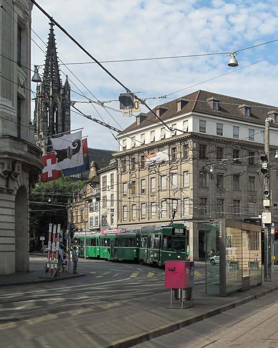 Ein grünes Tram vor alten Geschäftshäusern am St. Alban-Graben in Basel